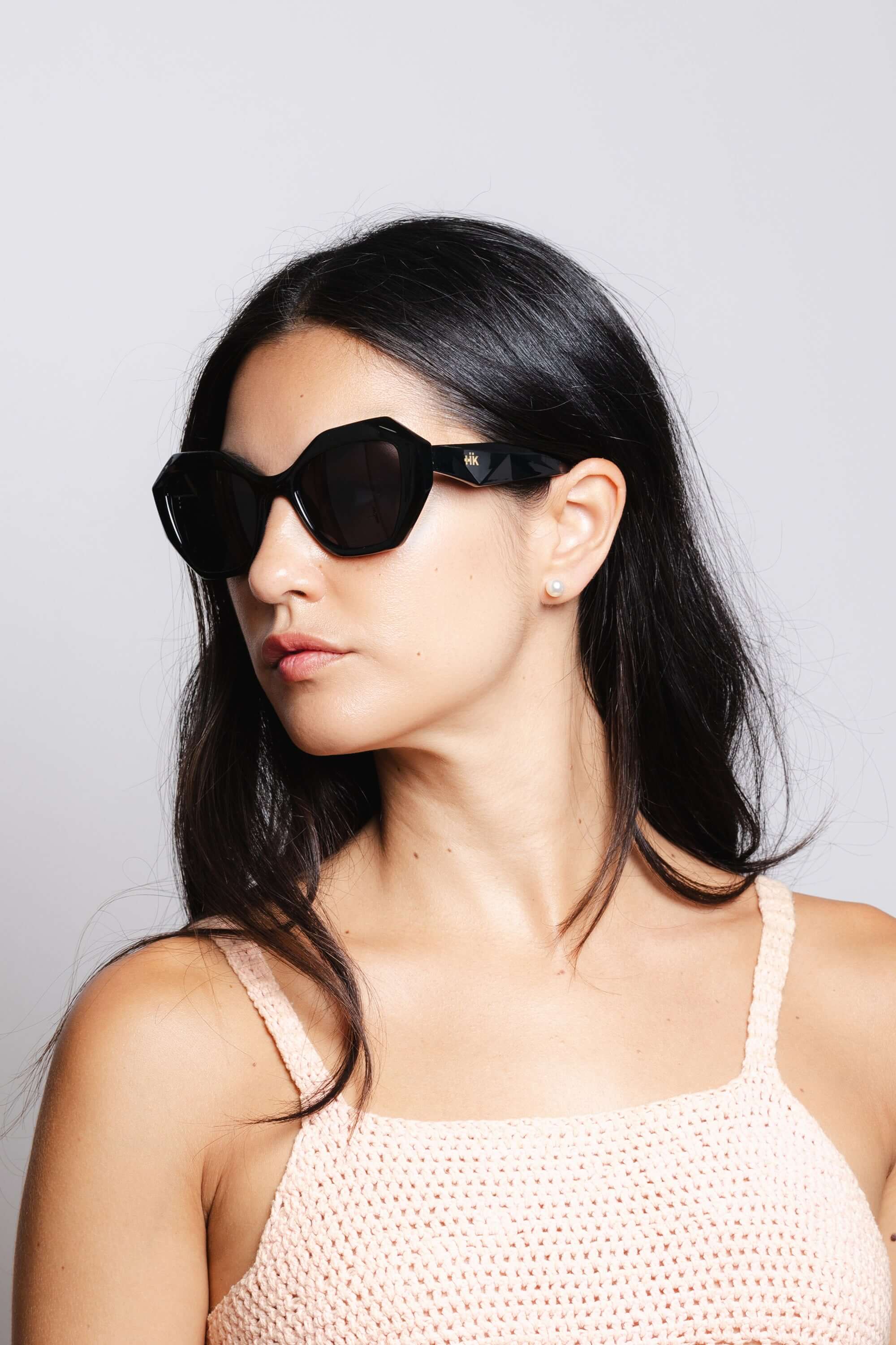 Mujer usando gafas de sol Hanukeii® Moorea Black / Black con montura negra y lentes oscuros.